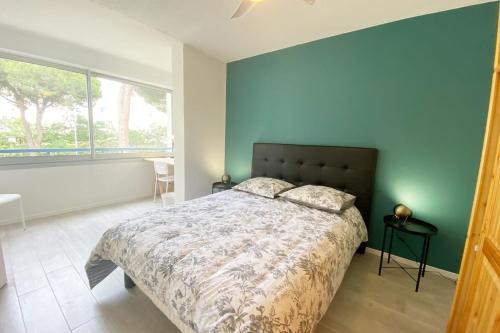 une chambre avec un grand lit et une grande fenêtre dans l'établissement LE ESTELLA APPART - PARKING WIFI au CALME 2 Min PLAGES - Résid LE RAYOL - TOP PROS SERVICESConciergerie La Grande Motte, à La Grande Motte