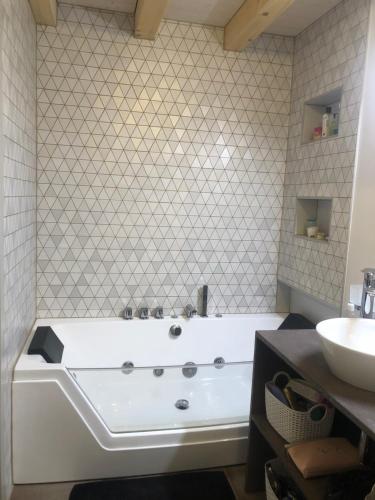 a large white tub in a bathroom with a sink at Gaspoz in Morgins