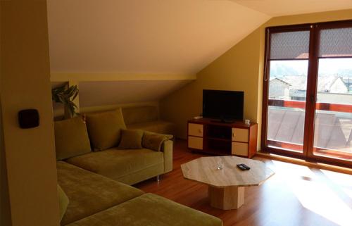 
a living room filled with furniture and a window at Penzión Tulip in Červený Kláštor
