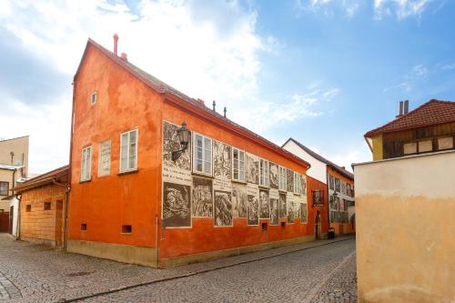 an orange building with drawings on the side of it at Pension Paseka in Litomyšl