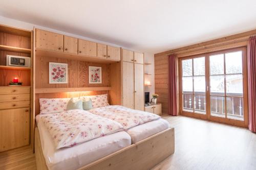 a bedroom with a bed and a large window at Haus Pfannenhölzer in Bad Hindelang