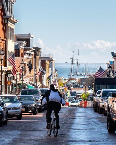 a person riding a bike down a city street at 134 Prince - Luxury Boutique Hotel in Annapolis