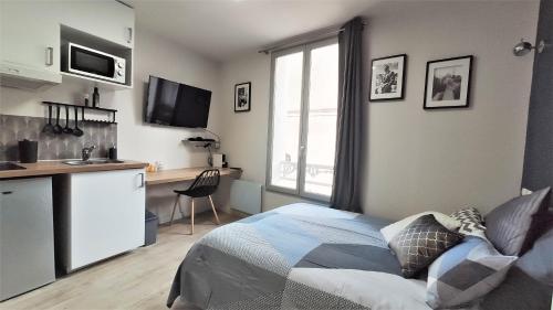 Cet appartement comprend une chambre avec un lit et une cuisine avec une fenêtre. dans l'établissement Home&Work 201 - HYPERCENTRE - fibre et parking a proximité, à Niort