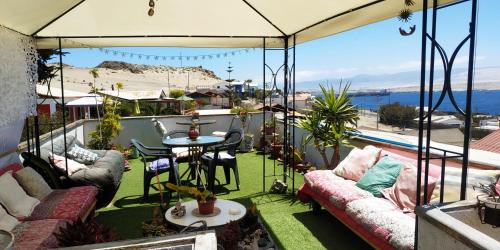 balcón con sofás, mesa y vistas al océano en El Faro en Caldera