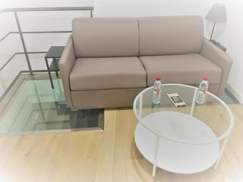 a living room with a couch and a glass table at COSY PUTEAUX QUAI DION BOUTOn in Puteaux