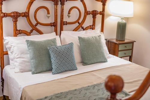 a bedroom with a bed with white and green pillows at Masseria Torre Spagnola in Matera