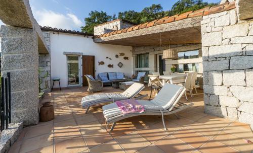a patio with chairs and a table in a building at BGItalianVacation - Ville Li Conchi in Castiadas