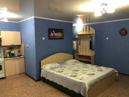 Tuymazyにあるtwo-room apartments on Lenin 19 avenueの青い壁のベッドルーム1室(ベッド1台付)