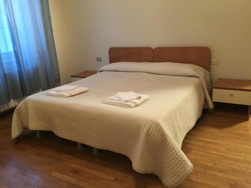 a bedroom with a bed with two towels on it at Marconi 18 in Gallarate