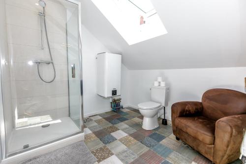 uma casa de banho com um chuveiro, uma cadeira e um WC. em Quiberon centre ville, plage 300m em Quiberon