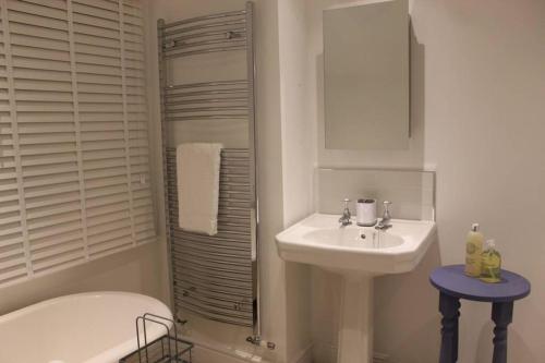a white bathroom with a sink and a shower at Luxury townhouse in town centre, views, river walk in Shrewsbury