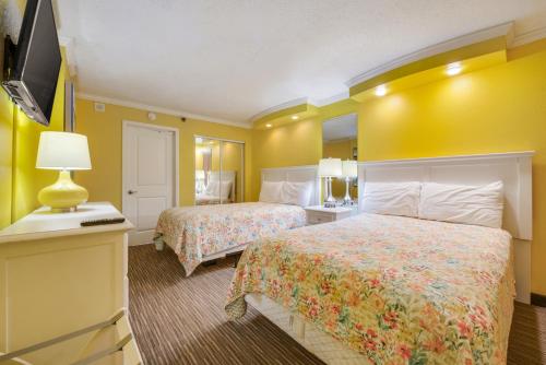 a hotel room with two beds and a television at Direct oceanfront, separate bedroom condo, 9th floor, unbelievable views! in Myrtle Beach