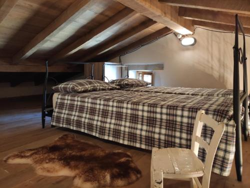 PolinagoにあるCastello di Brandolaのベッドルーム1室(ベッド1台、椅子、ラグ付)