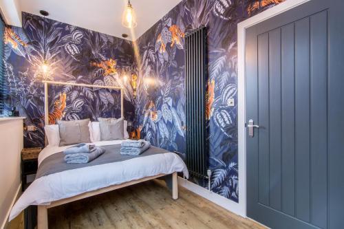 The Brewery Apartments في ستوكبورت: غرفة نوم مع سرير بورق جدران أزرق وبرتقالي