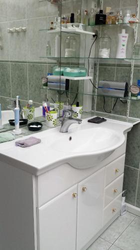 une salle de bain avec un lavabo blanc et un miroir dans l'établissement 2 chambres privées dans un jardin d'hiver, garage voiture, vélos, motos, à Tourville-sur-Arques