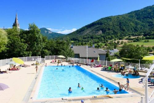 un groupe de personnes dans une piscine dans l'établissement Joli appartement T2 au village de Rochebrune 05190, à Rochebrune