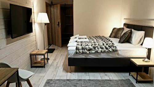 a bedroom with a large bed with a television on it at Villa Olimpijska 2 - Centrum in Wisła