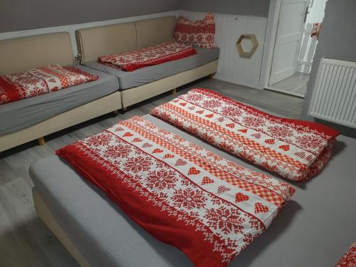 two beds in a room with red and white blankets at Adel Cottage-SAUNA-HOT TUBE in Kovářská