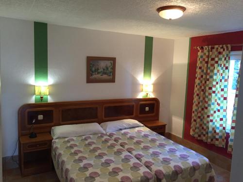 um quarto com uma cama grande e 2 luzes acesas em Apartamentos colon y bungalows em Los Quemados