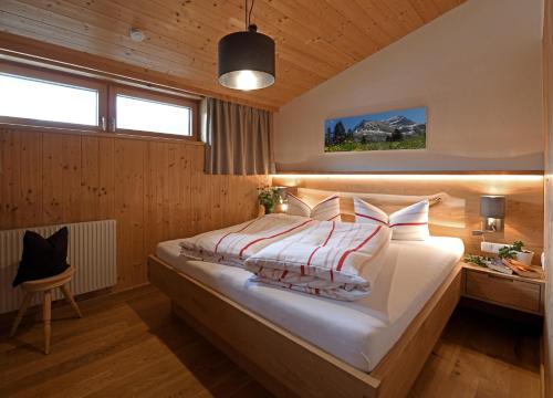 a bedroom with a large bed and a desk at Kinderbauernhof in Schoppernau
