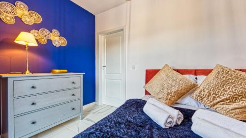 a blue bedroom with a bed and a dresser at Apartament Sępia Góra Premium z Sauną - 5D Apartamenty in Świeradów-Zdrój