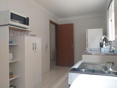 a kitchen with a white refrigerator and a sink at Antonia Haddad in Lorena