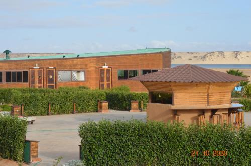 a brick building with a small wooden building at Dakhla Kitesurf World in Dakhla