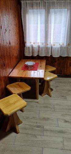 a table and two benches in a room with a window at Domacinstvo Prentovic in Čajetina