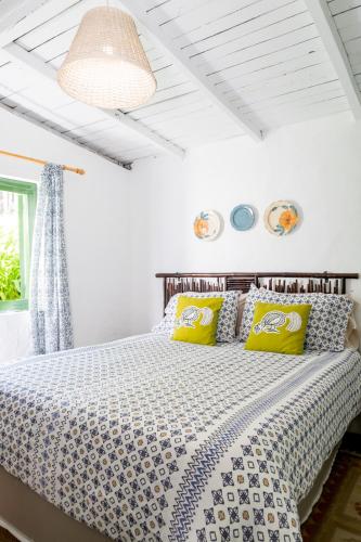 a bedroom with a large bed with yellow pillows at Villa Pajon Eco Lodge in Constanza