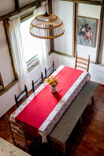 a dining room table with a red tablecloth and two chairs at Villa Pajon Eco Lodge in Constanza
