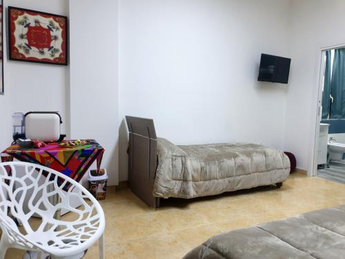 ein Wohnzimmer mit einem Bett und einem Stuhl in der Unterkunft B&B HERCULANEUM RUINS in Ercolano