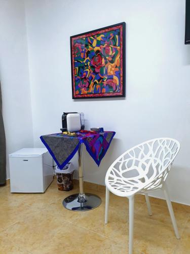 a table and a chair in a room with a painting at B&B HERCULANEUM RUINS in Ercolano