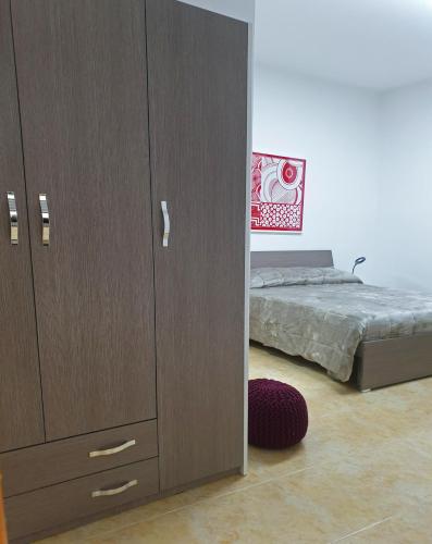 a bedroom with a large wooden cabinet and a bed at B&B HERCULANEUM RUINS in Ercolano