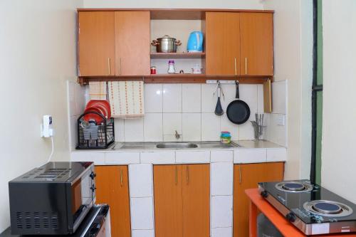 una pequeña cocina con fregadero y microondas en Rubistones en Naivasha