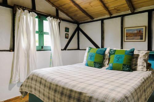 a bedroom with a bed with a checkered blanket at Villa Pajon Eco Lodge in Constanza