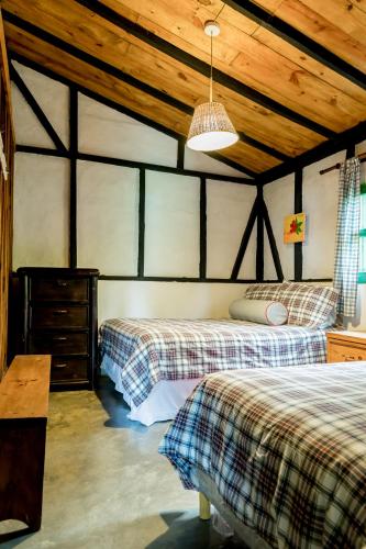 a bedroom with two beds and a wooden ceiling at Villa Pajon Eco Lodge in Constanza