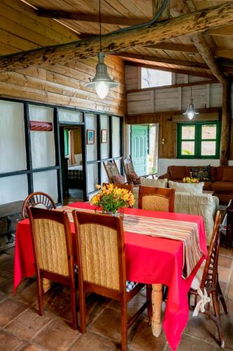 a dining room with a red table and chairs at Villa Pajon Eco Lodge in Constanza