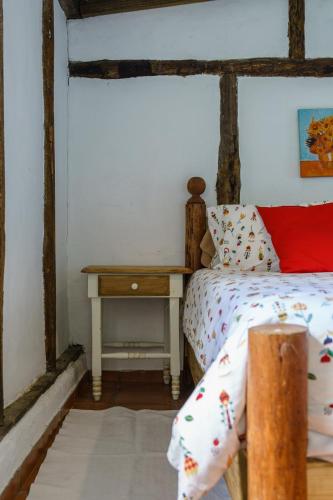 a bedroom with a bed and a night stand with a table at Villa Pajon Eco Lodge in Constanza