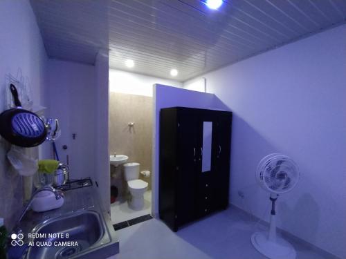 a bathroom with a black door and a fan at Apartaestudios El Descanso in Cali