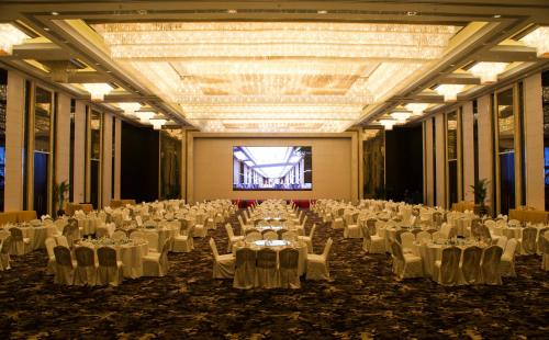 a large banquet hall with white tables and chairs at Yangzhong Firth Jinling Grand Hotel in Yangzhong