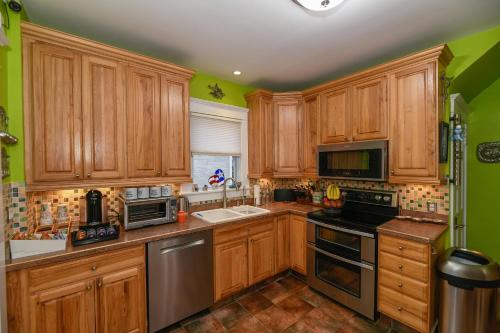 a kitchen with wooden cabinets and stainless steel appliances at Berrodin Bed & Breakfast in Akron