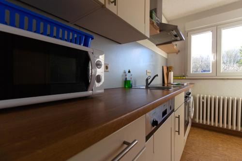 a kitchen with a microwave on top of a counter at Zwischen Köln und Bonn, Central oben in Troisdorf