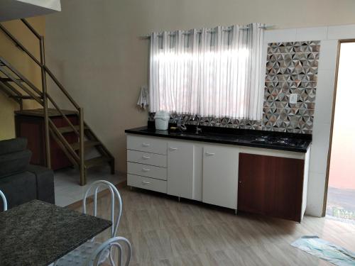 a kitchen with a counter and a staircase in a room at Loft em Botucatu prox unesp rubiao jr in Botucatu