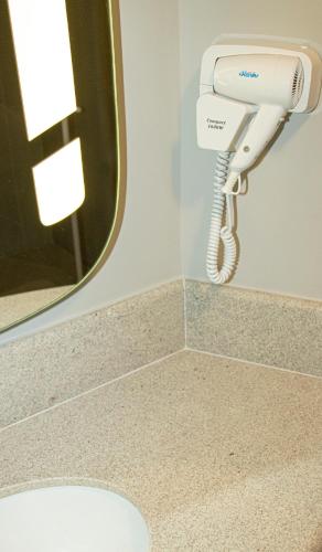 a hair dryer in a bathroom with a mirror at ibis Sao Paulo Tatuape in Sao Paulo