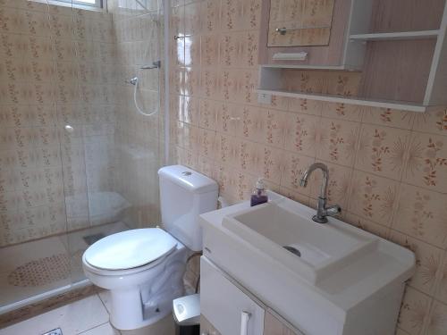 a bathroom with a toilet and a sink and a shower at CASA 3 MIN a PÉ da PRAIA DO FORTE - CHURRASQUEIRA - WI FI in Cabo Frio