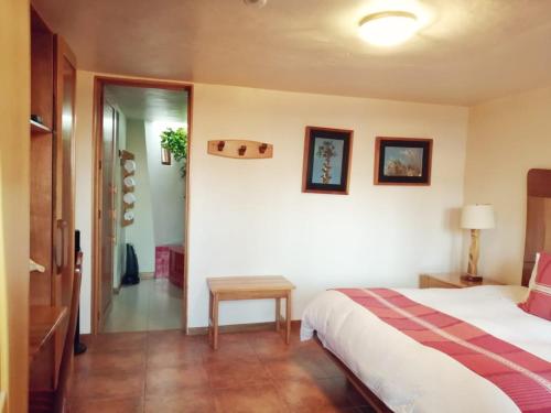 a bedroom with a bed and a table in it at Casa Tsaya Hotel Boutique in Bernal