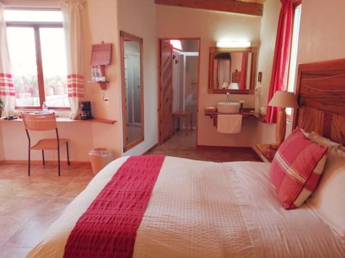 a bedroom with a large bed and a bathroom at Casa Tsaya Hotel Boutique in Bernal