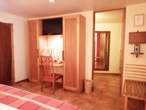a bedroom with a bed and a desk with a chair at Casa Tsaya Hotel Boutique in Bernal