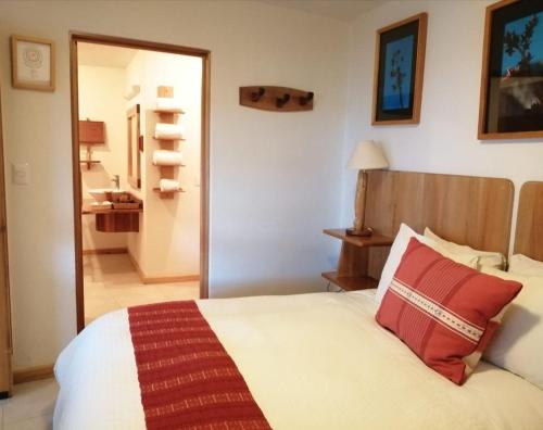a bedroom with a bed with red pillows on it at Casa Tsaya Hotel Boutique in Bernal