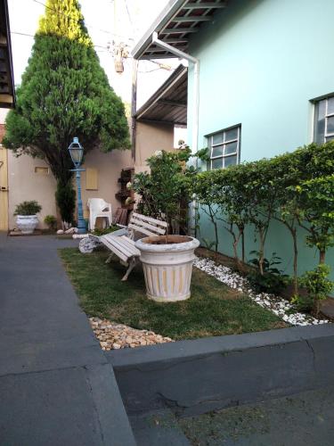 a garden with a bench in front of a house at Casa 2 dorm em Botucatu próx unesp in Botucatu